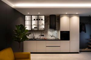 a kitchen with white cabinets and a potted plant at Apartman Mali raj in Pakoštane