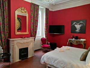 a red bedroom with a bed and a fireplace at les jardins de la fontaine in Alès