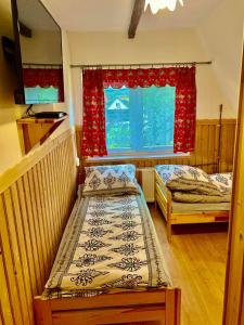 two beds in a room with a window at Pokoje Gościnne u Marysi in Białka Tatrzańska