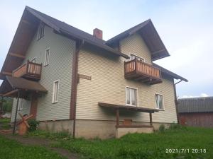 una casa con 2 balcones en un lateral en У Марка, en Volosyanka