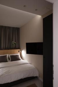 een slaapkamer met een bed en een flatscreen-tv bij Apartman Mali raj in Pakoštane