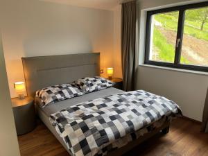 Un dormitorio con una cama en blanco y negro y una ventana en Modern Living Sankt Gilgen en Sankt Gilgen