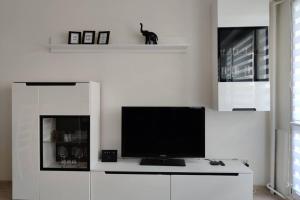 TV en un armario blanco en la sala de estar en Apartament Na 8 Piętrze, en Płock