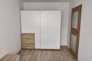 a white cabinet in a room with a wooden floor at Apartament Na 8 Piętrze in Płock