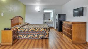 a bedroom with a bed and a flat screen tv at Studios and Suites 4 Less Emporia in Emporia