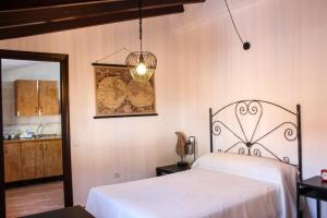 a bedroom with a white bed and a chandelier at Apartamentos La Mar Chica in Benalmádena