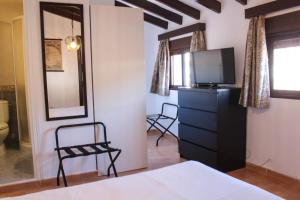 una camera con letto, TV e cassettiera di Apartamentos La Mar Chica a Benalmádena