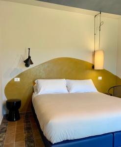 a bedroom with a large bed with a large headboard at Il Poggio di Musignano in Musignano