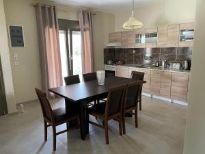 y cocina con mesa de comedor y sillas. en Villa Soula en Paralía Avdhíron