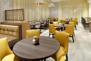 a dining room with tables and yellow chairs at Hyatt Place Miami Airport East in Miami