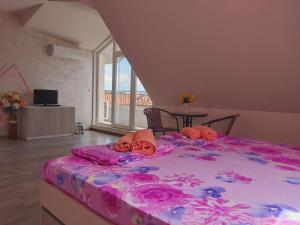 a bedroom with a large bed with roses on it at Bogdanovi Guest House in Chernomorets