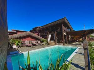 a resort with a swimming pool in front of a building at Pousada Villa Prainha in Farol de Santa Marta