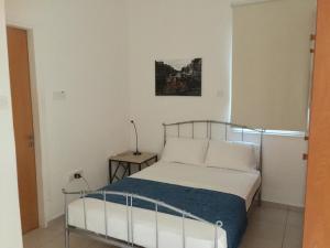 a bedroom with a bed and a lamp on a table at Davi's Studio Apartment in Paphos