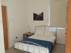 a bedroom with a bed and a lamp on a table at Davi's Studio Apartment in Paphos City