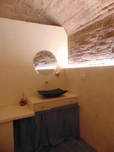 een badkamer met een wastafel en een spiegel aan een muur bij Montalcinello Casavolta WIFI, aria condizionata in Montingegnoli
