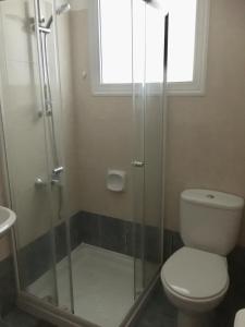 a bathroom with a toilet and a glass shower at Davi's Studio Apartment in Paphos City