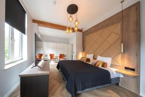 a bedroom with a bed and a desk and a television at Boutique Hotel Scheepers in Valkenburg