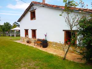 una casa blanca con un banco en un patio en Casa Pepín - Sagasta Rural Oviedo, en Oviedo