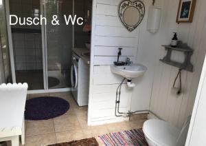 La salle de bains est pourvue d'un lavabo, d'une douche et de toilettes. dans l'établissement Torpet Längtan, à Ullared