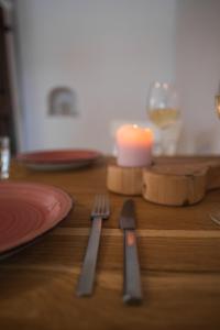 una mesa con una vela y un tenedor y un cuchillo en Rarität Mein Herzenshaus im Altmühltal en Walting