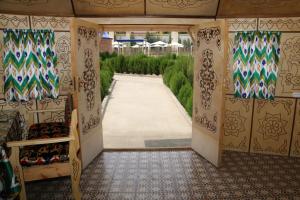 an entrance to a garden with a walkway at Hotel Gumbaz in Samarkand