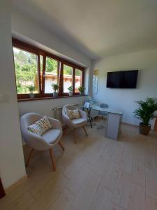 a living room with chairs and a table and a tv at El Cuadron in Camango