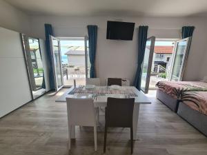 a dining room with a table and chairs and a bedroom at Apartments Elizabeta in Dramalj