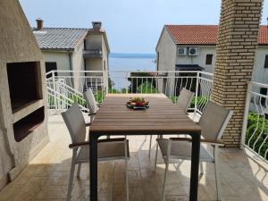 a wooden table and chairs on a balcony at Apartments Elizabeta in Dramalj