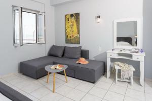 a living room with a couch and a table at Sole Mare Seaside Apartments in Gouves