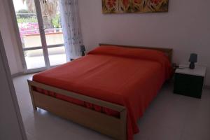 a bedroom with a red bed and a window at Villa Angelina in Marausa