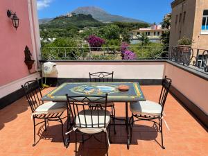 a table and chairs on a balcony with a view at Villa Aura in Torre del Greco