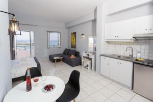 a kitchen and living room with a table and chairs at Sole Mare Seaside Apartments in Gouves