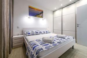 sypialnia z dużym łóżkiem z niebieską i białą pościelą w obiekcie Beach Makarska Apartment w Makarskiej
