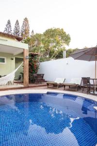 una piscina con sillas y sombrilla en Luar de Geribá en Búzios