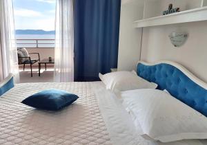 a bedroom with a large bed with a blue headboard at Villa Skalinada with sea view in Brela