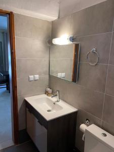 ein Badezimmer mit einem Waschbecken, einem Spiegel und einem WC in der Unterkunft Villa Soula in Paralía Avdhíron