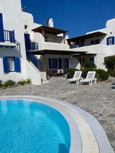 a large swimming pool in front of a house at Pigeon House Ornos Beach in Mikonos