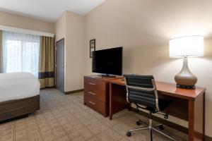 a hotel room with a bed and a desk with a computer at Comfort Inn & Suites in Mankato