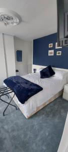- une chambre avec un grand lit et un mur bleu dans l'établissement Sycamore House, à Laurière