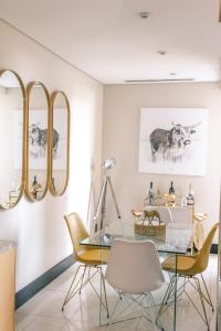 a dining room with a glass table and yellow chairs at Raphael penthouse 205 in Johannesburg