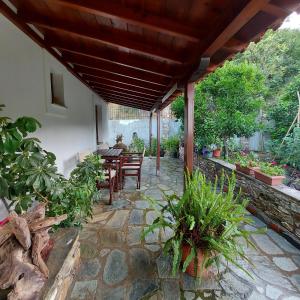 a patio with a table and chairs and plants at Villa Amfithea in Skiathos