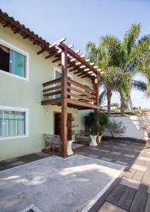 una casa con una pérgola de madera a un lado en Luar de Geribá, en Búzios