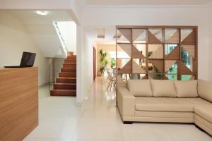 Una sala de estar con un sofá y una escalera. en Luar de Geribá, en Búzios