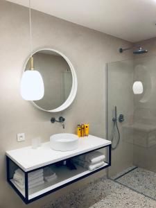 a bathroom with a sink and a mirror and a shower at Suites Le Porte-Bonheur in Bruges