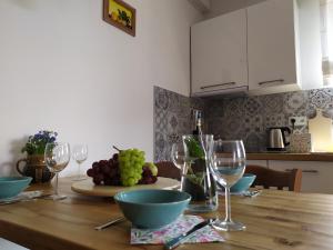 a wooden table with wine glasses and a bowl of grapes at Kaszubska Przystań in Brzeźno Szlacheckie