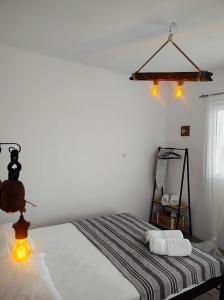 a bedroom with a bed and two lights on the wall at Prickly Pear House in Plaka Milou