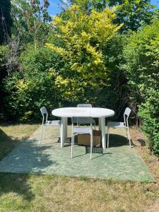 una mesa blanca y dos sillas sentadas a su alrededor en Garden House, en Sopot