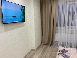 un televisor colgado en una pared en una habitación en ВІП Апартаменти в районі автовокзалу,ЖК Арена,ПОБЛИЗУ ОБЛАСНОІ ЛІКАРНІ, en Rivne