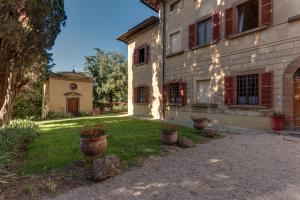 a house with two potted plants in the yard at Villa Bonsi in Montaione