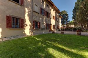un edificio con un césped verde delante de él en Villa Bonsi, en Montaione